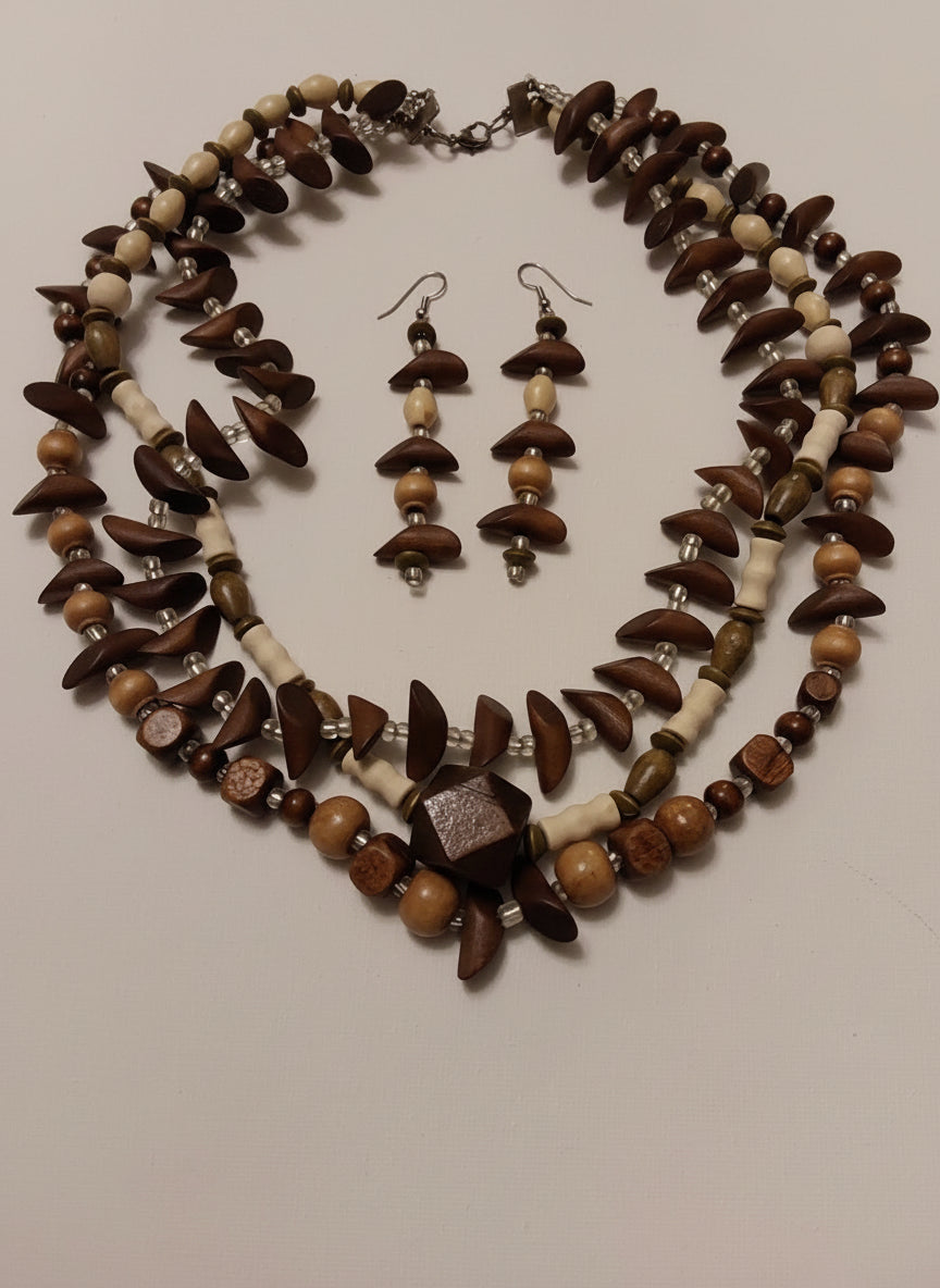 Necklace and earrings with brown and beige beads on a light pink background